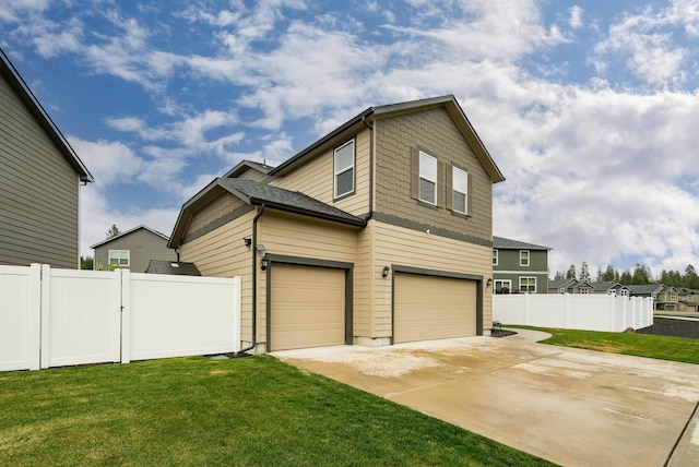 view of side of property featuring a yard, driveway, fence, and a garage
