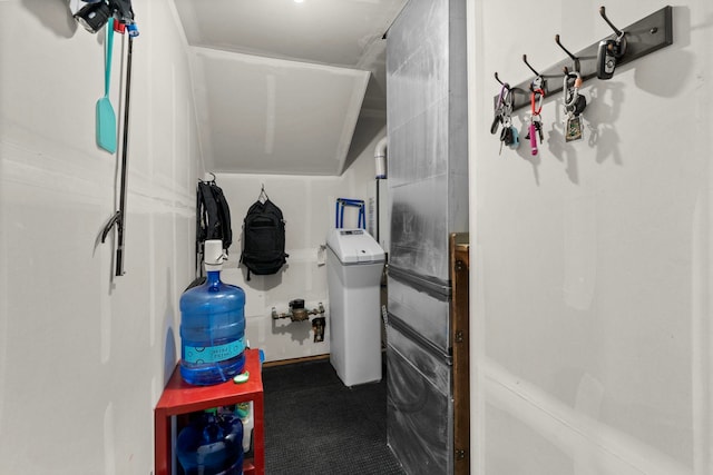 hallway with baseboards, light colored carpet, and washer and clothes dryer