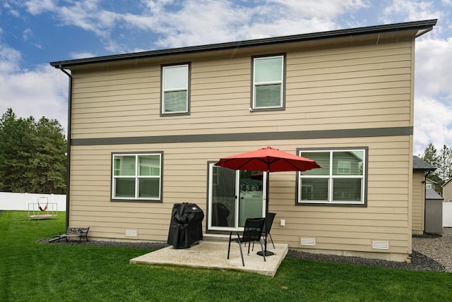 rear view of property with a yard, fence, and a patio area