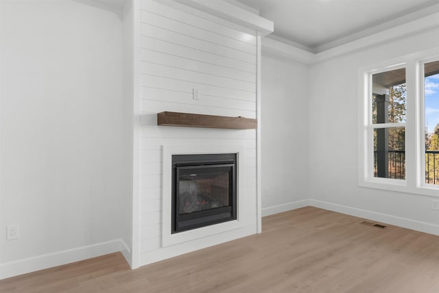 unfurnished living room with a fireplace and light wood-type flooring