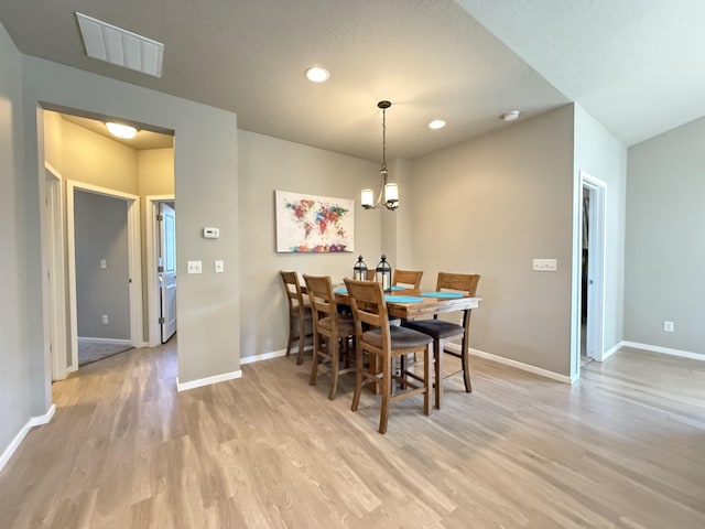 dining space featuring an inviting chandelier and light wood-type flooring