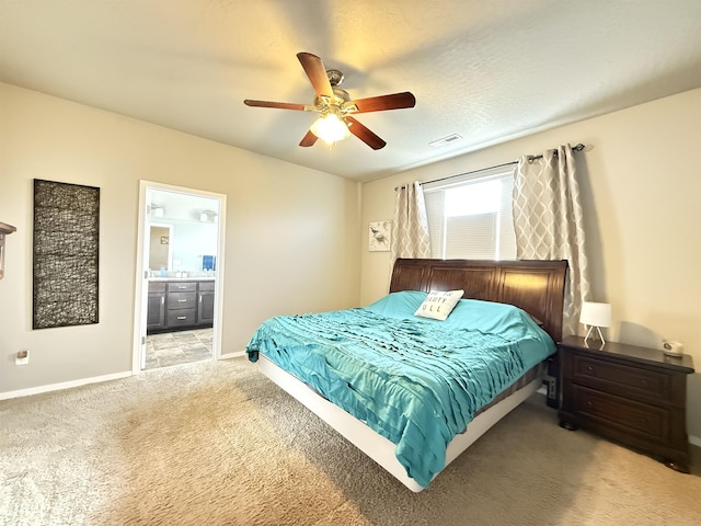 carpeted bedroom with ceiling fan and ensuite bath