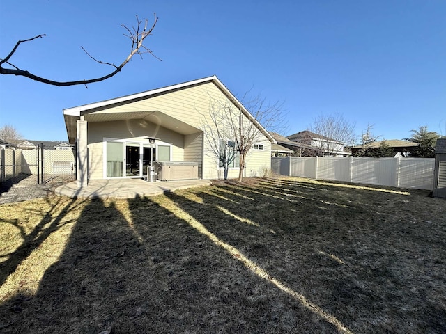 rear view of house featuring a lawn and a patio area