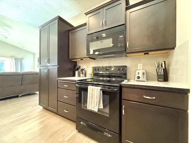 kitchen with vaulted ceiling, light wood-type flooring, black appliances, dark brown cabinets, and a textured ceiling