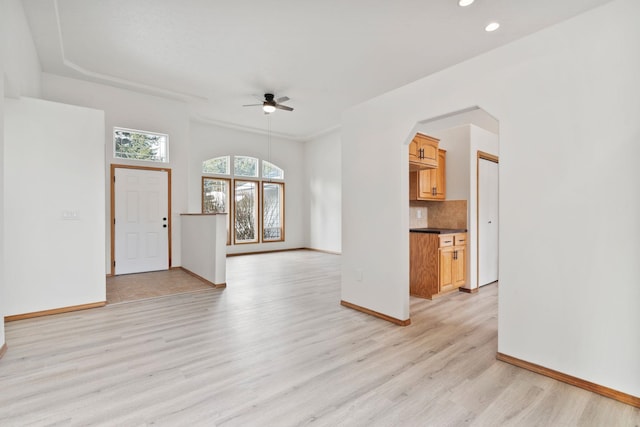 unfurnished living room featuring ceiling fan and light hardwood / wood-style floors