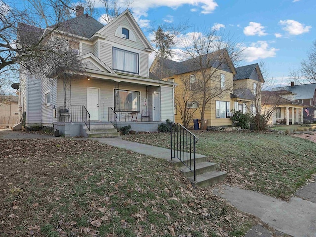 view of front of property with a porch and a front lawn