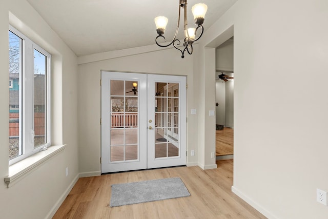 doorway to outside featuring light hardwood / wood-style flooring, vaulted ceiling, french doors, and a healthy amount of sunlight