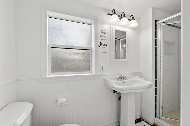 bathroom with an enclosed shower, wooden walls, and toilet