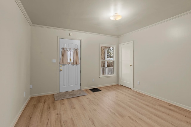 foyer with ornamental molding and light hardwood / wood-style floors