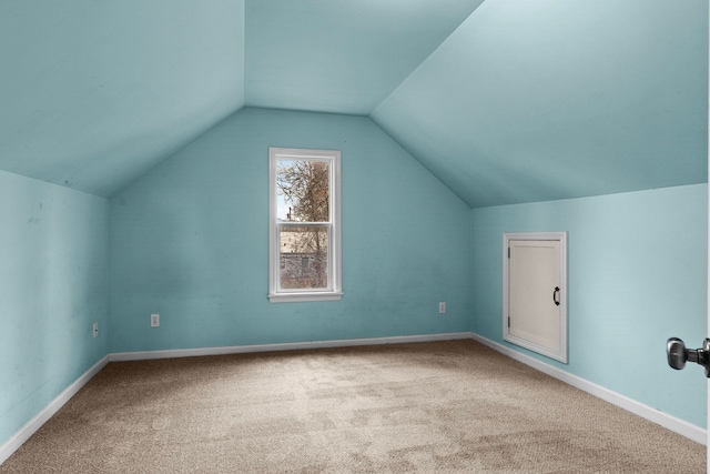 bonus room with vaulted ceiling and carpet floors