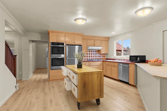 kitchen featuring wooden counters, backsplash, stainless steel appliances, light brown cabinets, and light wood-type flooring