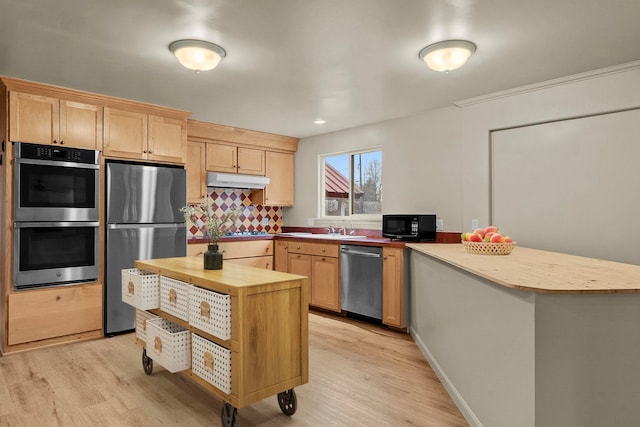 kitchen featuring appliances with stainless steel finishes, light brown cabinetry, butcher block countertops, sink, and light hardwood / wood-style floors