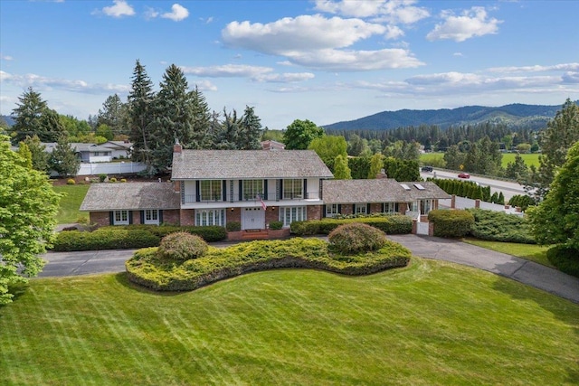 view of front of property with a mountain view and a front lawn