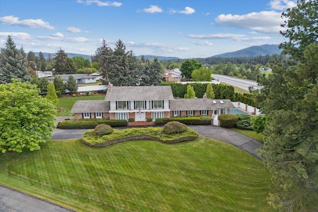 view of front facade with a mountain view and a front lawn