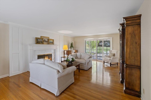 living room with a tile fireplace and light hardwood / wood-style flooring