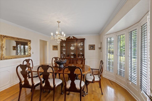 dining space featuring ornamental molding, a chandelier, and light wood-type flooring