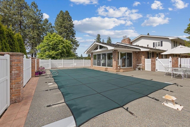 view of swimming pool featuring a patio area and a sunroom