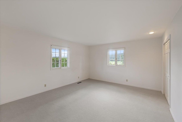 unfurnished room with a healthy amount of sunlight and light carpet