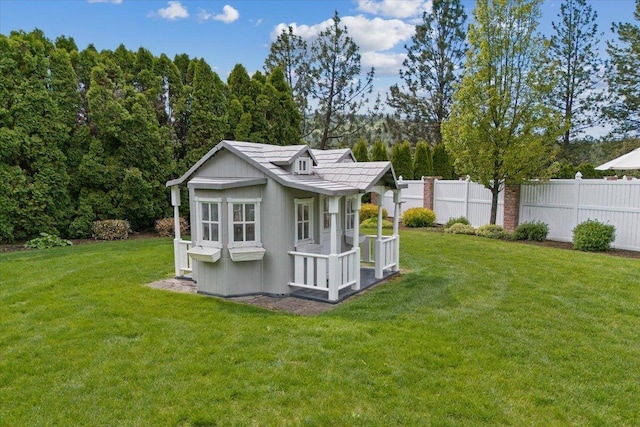 back of house featuring a yard and an outbuilding