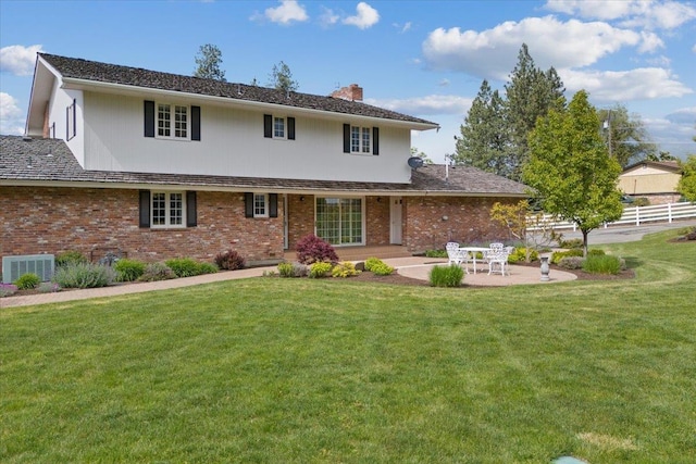 back of property featuring central AC, a lawn, and a patio