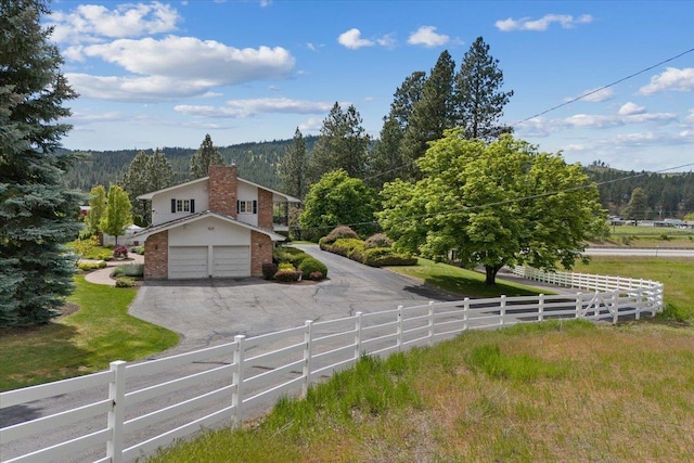 view of front of house featuring a garage and a rural view