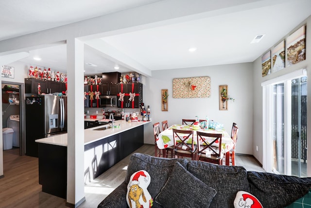 kitchen featuring appliances with stainless steel finishes, sink, kitchen peninsula, and hardwood / wood-style floors