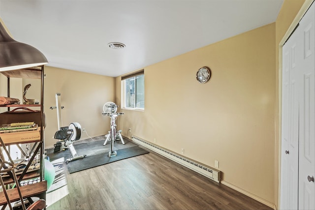 exercise room with a baseboard heating unit and hardwood / wood-style floors