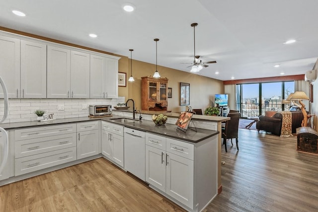 kitchen with white cabinetry, hanging light fixtures, kitchen peninsula, and dishwasher