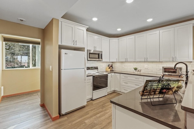 kitchen with white cabinetry, backsplash, white appliances, and light wood-type flooring