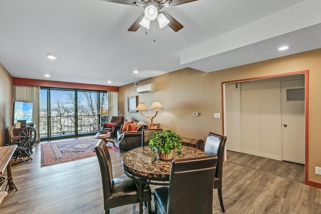 dining room featuring hardwood / wood-style floors, an AC wall unit, and ceiling fan