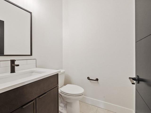 bathroom featuring vanity, tile patterned floors, and toilet