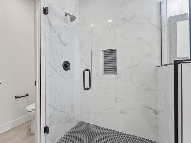 bathroom with toilet and a shower with shower door