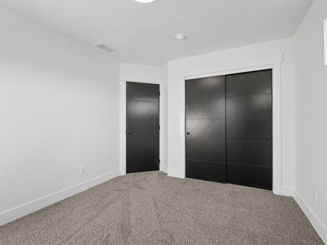 unfurnished bedroom featuring carpet flooring and a closet