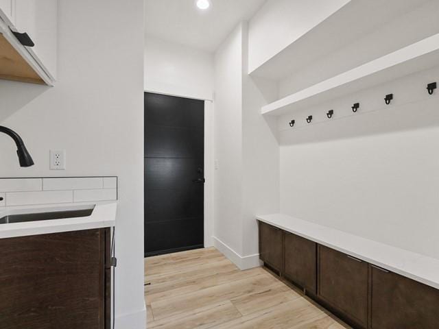 mudroom featuring sink and light hardwood / wood-style flooring