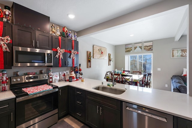 kitchen with appliances with stainless steel finishes, sink, and kitchen peninsula