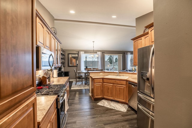 kitchen featuring decorative light fixtures, sink, dark hardwood / wood-style flooring, a chandelier, and stainless steel appliances