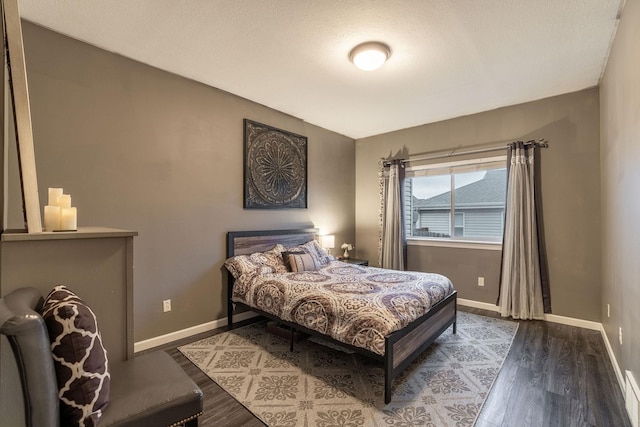 bedroom with dark hardwood / wood-style flooring and a textured ceiling