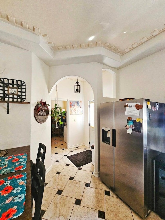 kitchen with a tray ceiling and stainless steel fridge with ice dispenser