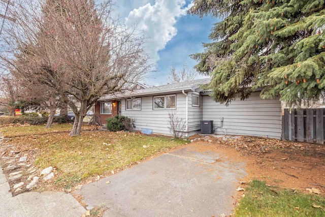 view of front of property with a front yard and central air condition unit