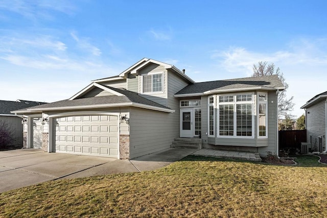 view of front of home featuring a garage, a front lawn, and central air condition unit