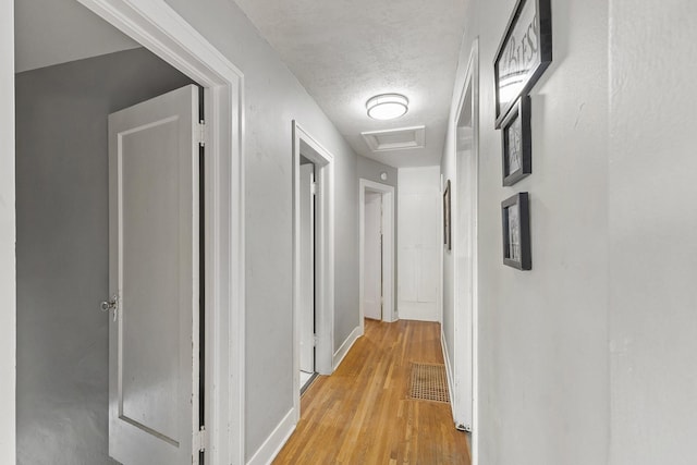 3224 W Cora Ave, Spokane, WA 99205 - corridor featuring visible vents, light wood-style floors, attic access, baseboards, and a textured ceiling
