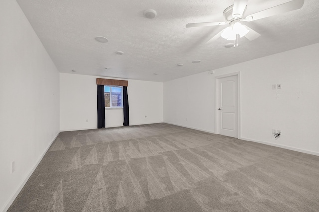 unfurnished room featuring ceiling fan, light colored carpet, and a textured ceiling