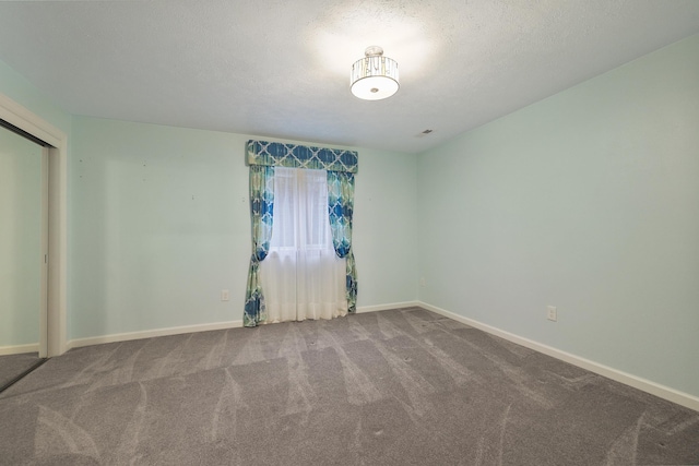 carpeted empty room featuring a textured ceiling