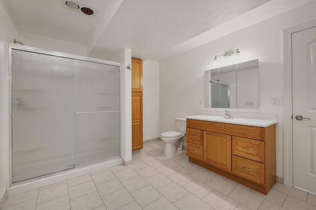 bathroom with tile patterned flooring, vanity, toilet, and a shower with shower door