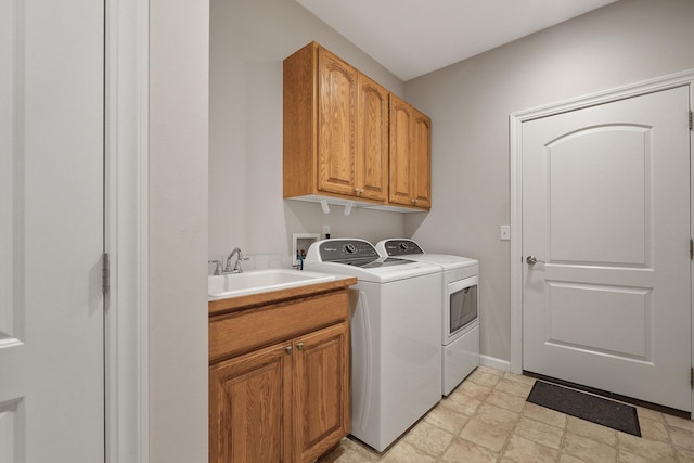 laundry room with cabinets, washer and clothes dryer, and sink