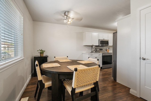 dining space with ceiling fan and dark hardwood / wood-style flooring