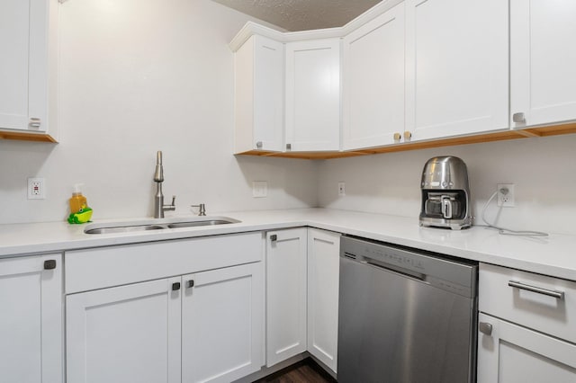 kitchen featuring stainless steel dishwasher, sink, a textured ceiling, and white cabinets