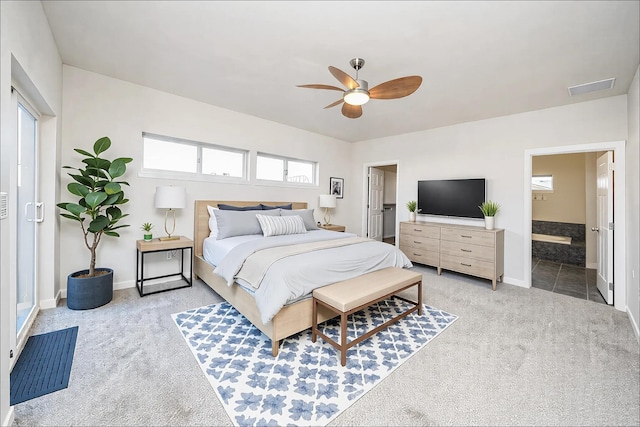 bedroom featuring ceiling fan, ensuite bath, and light carpet