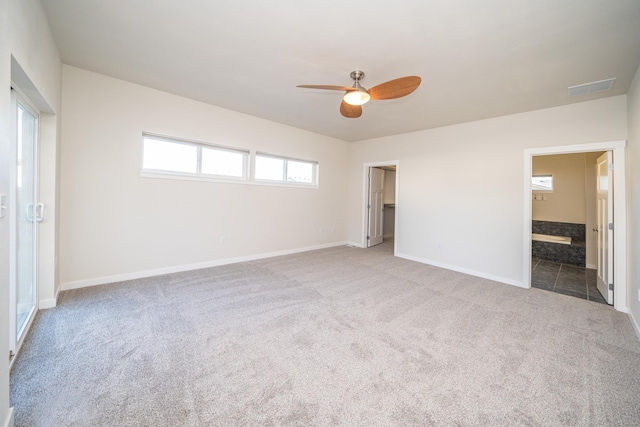 unfurnished bedroom featuring ceiling fan, ensuite bathroom, light carpet, a spacious closet, and a closet