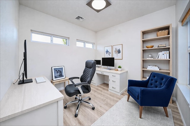 home office with light hardwood / wood-style floors